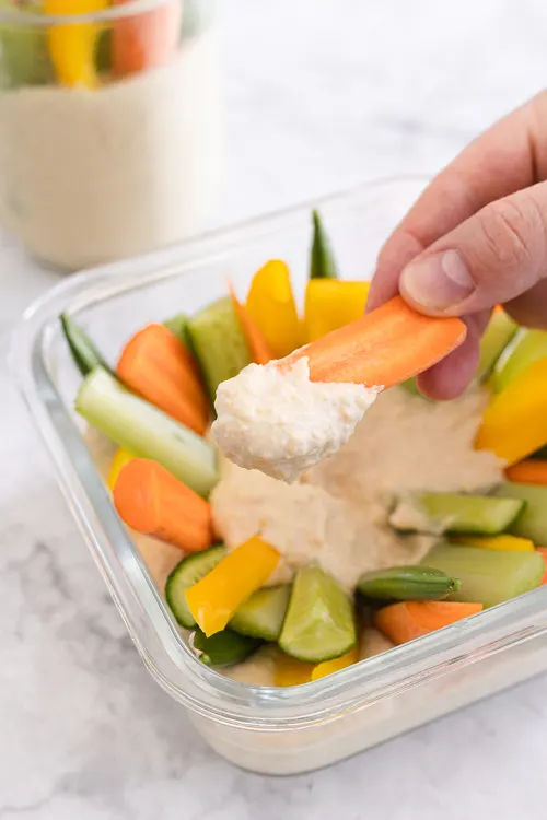 dipping a carrot into hummus