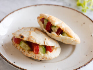 two Hummus Pita Pockets With Crunchy Veggies on a plate.