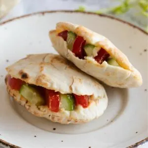 Two hummus pita pockets presented on a plate