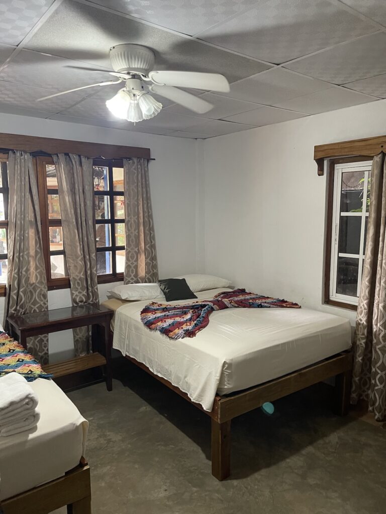 A bed is shown inside a cheap hotel room
